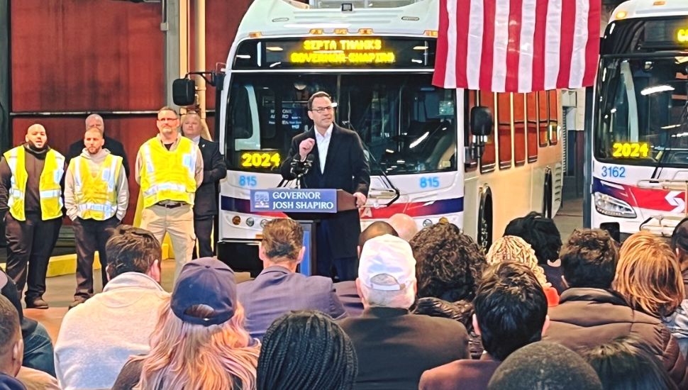 Josh Shapiro speaking inn front of a SEPTA bus.