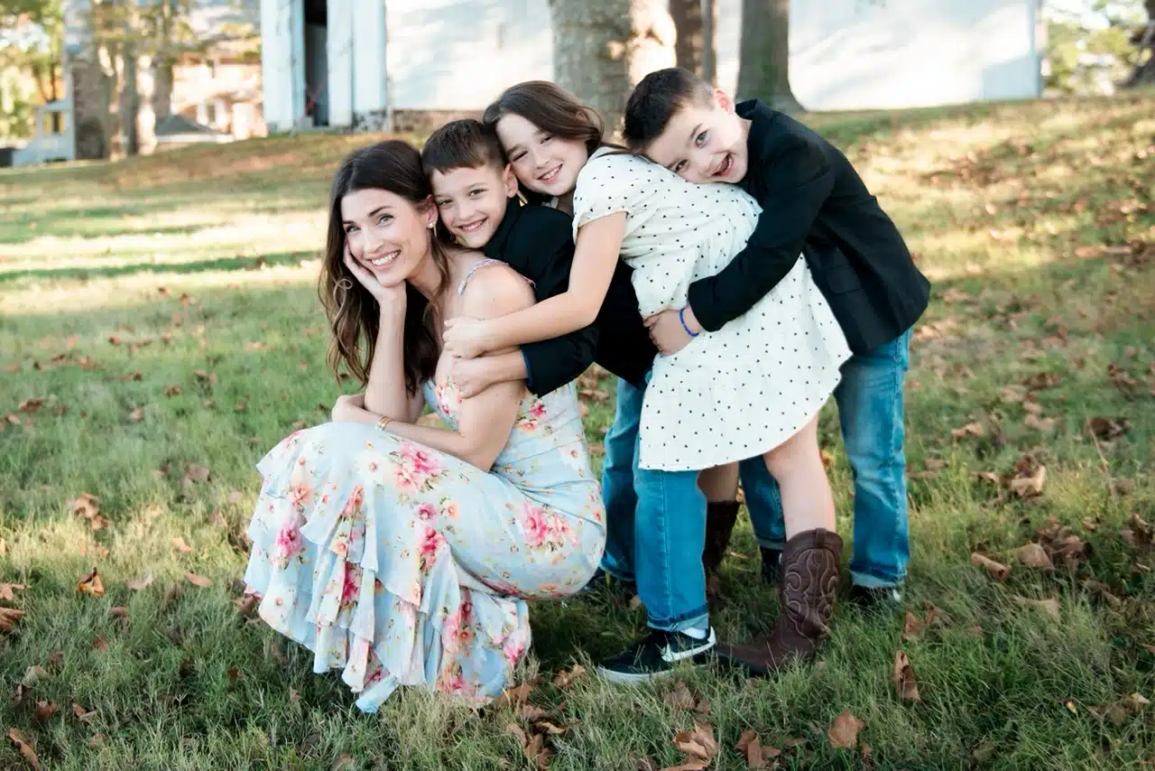 Ann Marks with three children posing on a lawn.
