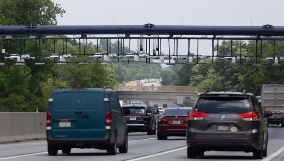 Cars driving under the Turnpike toll monitoring overpass before the Delaware River Bridge.