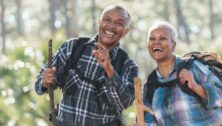 An older couple enjoy a walk in the woods.