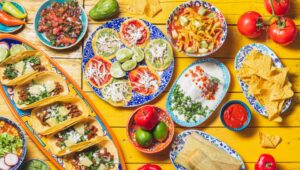 Table full of Mexican cuisine and plates.