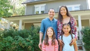 Happy family grouped in front of their new home.