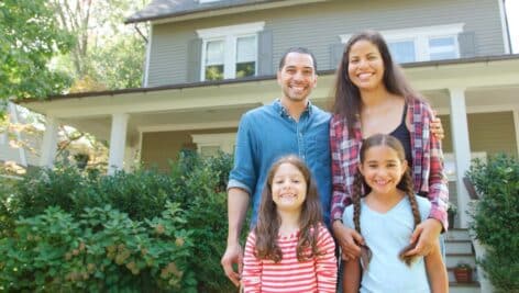 Happy family grouped in front of their new home.