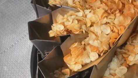 Fresh potato chips come rolling off the assembly line.