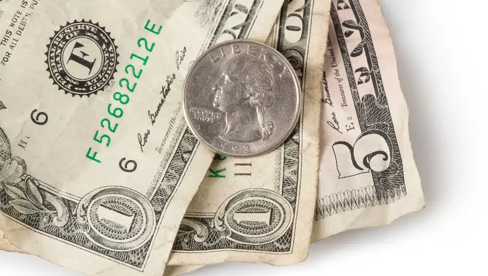 Wrinkled dollar bills and a quarter adding up to $7.25.