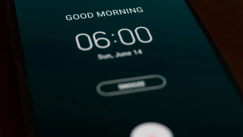 A smartphone alarm clock rings for 6 am