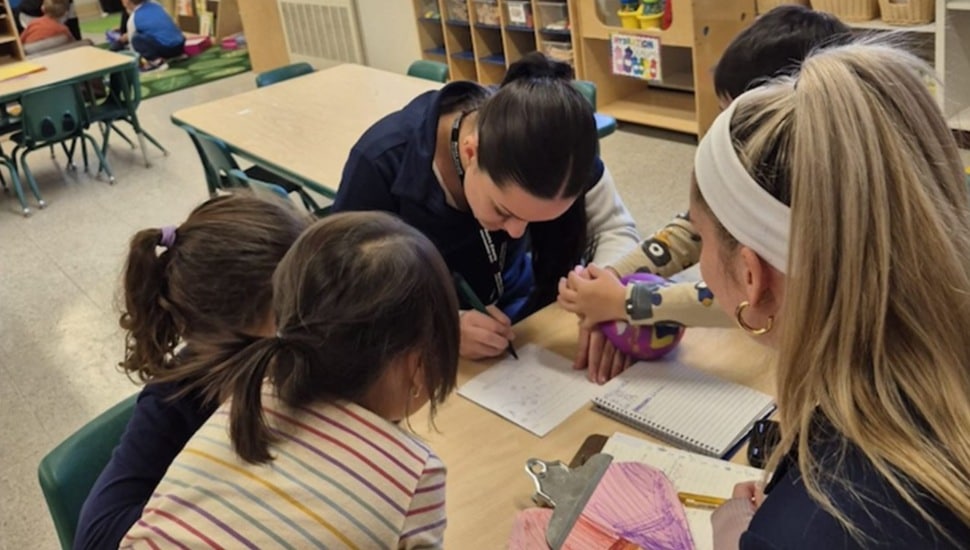 College student works with children in school.