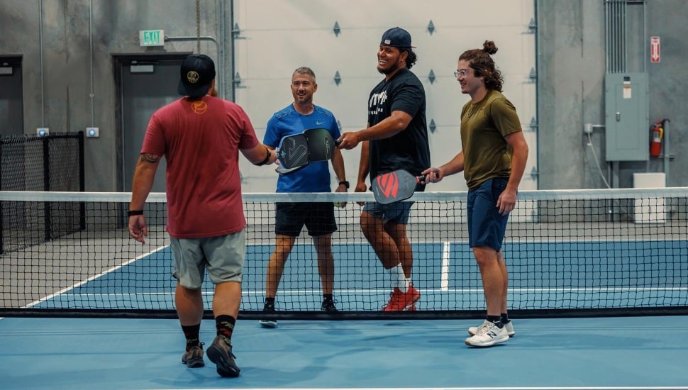 People on a Picklr pickleball court.