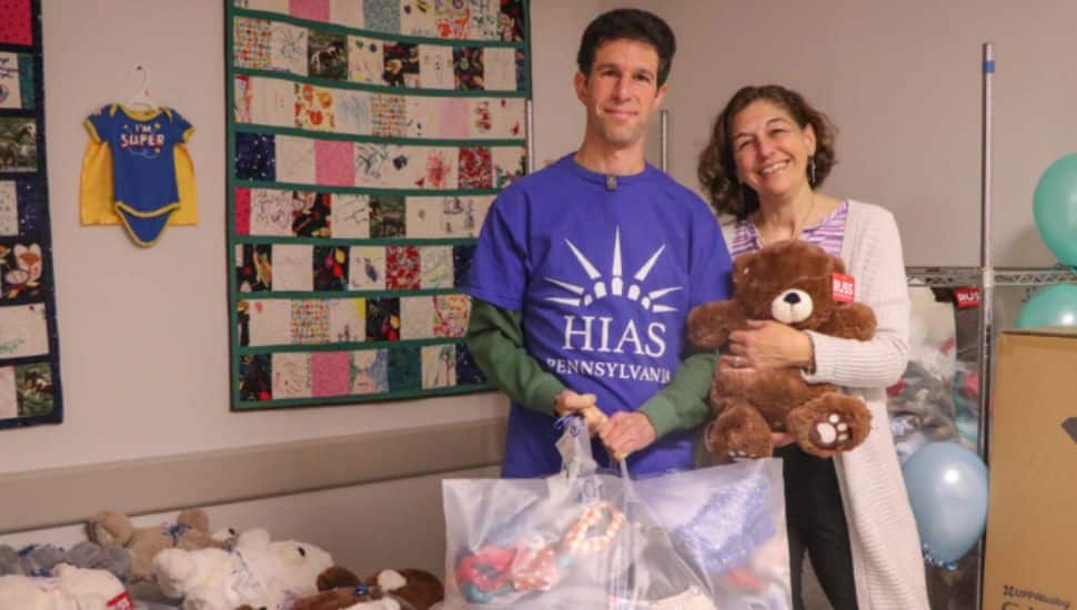 Two people holding baby bundles.