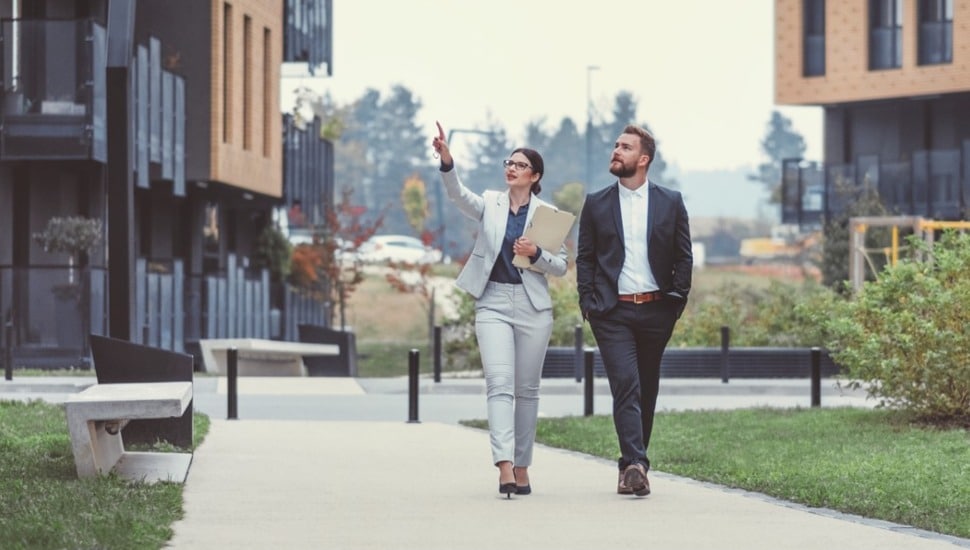 Two business people walking down the sidewalk.
