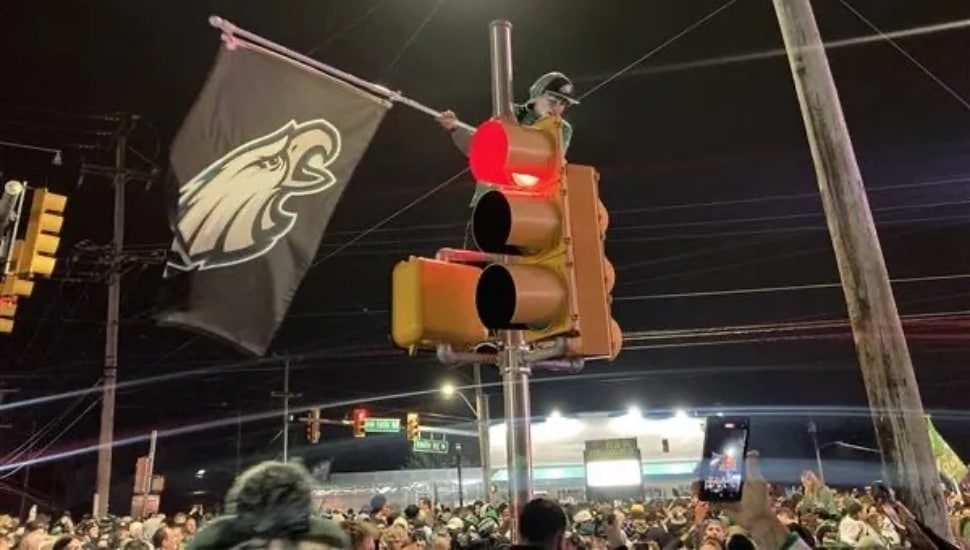 An Eagles fan climbs on the top of a light pole in Levitown after the Philadelphia Eagles win the Super Bowl.