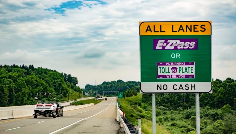 Pennsylvania Turnpike with sign and car on the road.