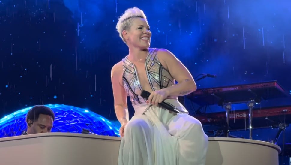 Pink on stage performing atop a piano.