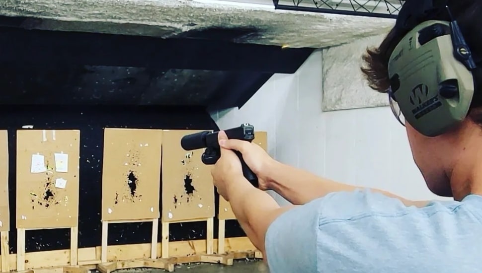 A man lines up a shot at a firing range.