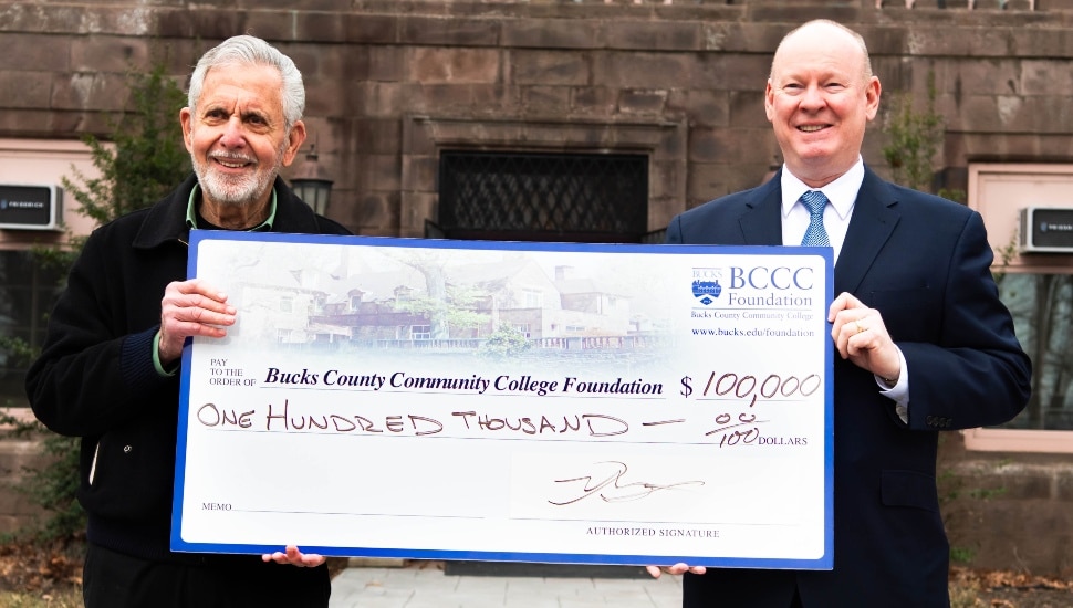 Gene Epstein presenting a $100,000 check to President & CEO Patrick M. Jones.
