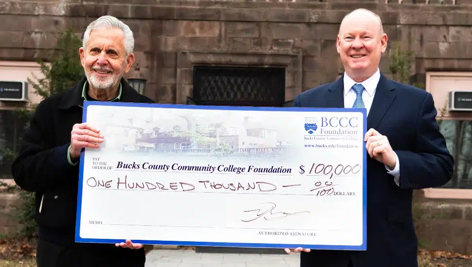Gene Epstein presenting a $100,000 check to President & CEO Patrick M. Jones.