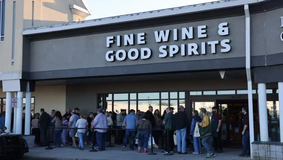 People standing outside a Fine Wine & Good Spirits store.