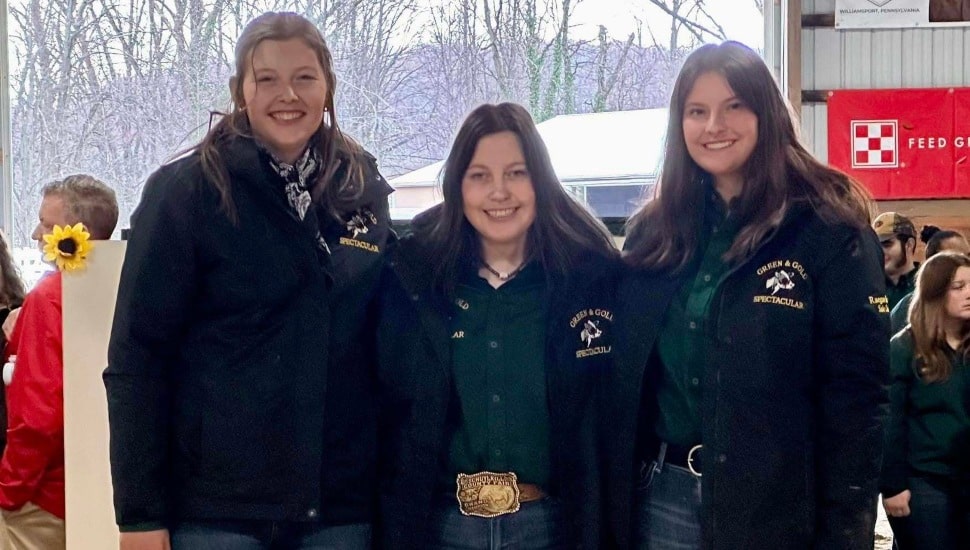 Agriculture college students pose for picture at a dairy sale.