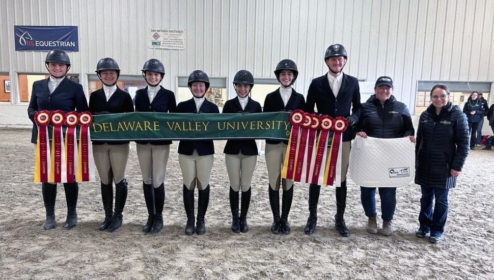 Equestrian competitors pose for a picture with awards.