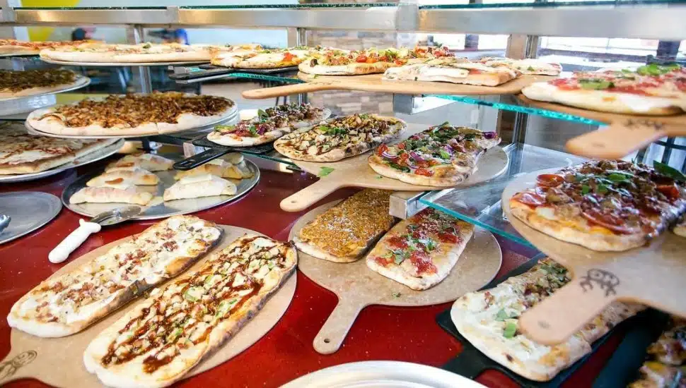 A bunch of pizza with different toppings.