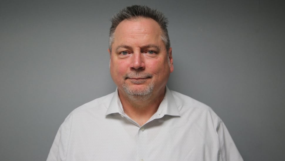 Headshot of middle-aged male union leader in white collared shirt.