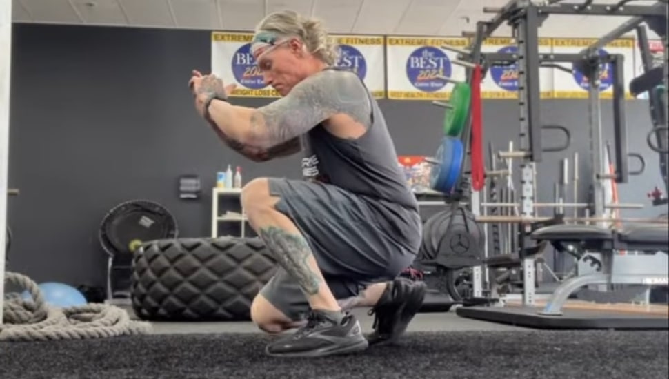 Marty McLoughlin performing a leg exercise while in a squat.