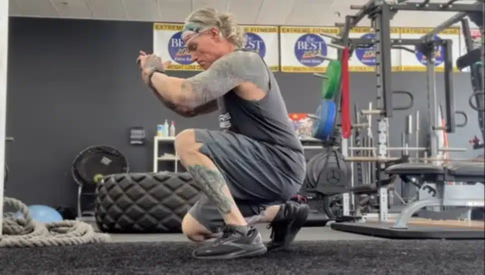 Marty McLoughlin performing a leg exercise while in a squat.