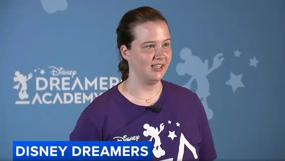 Téa Vukosavljevic speaking in front of a "Disney Dreamers Academy" wall.