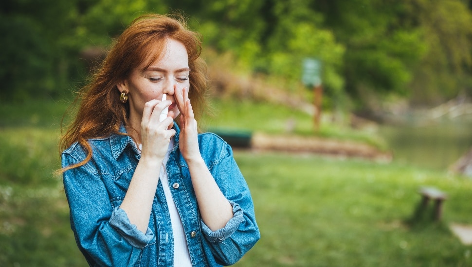 Woman using nasal spray.