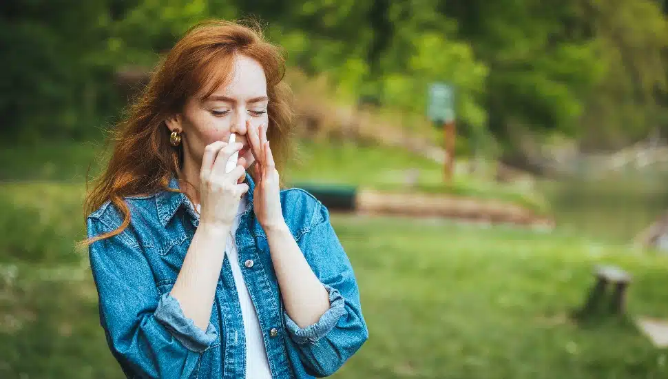 Woman using nasal spray.