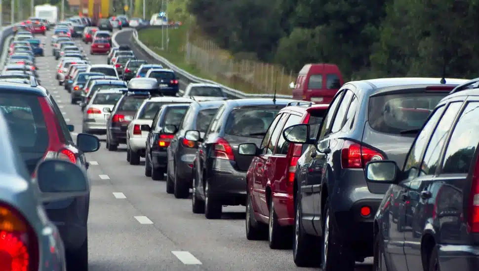 Cars lined up bumper to bumper on a highway.