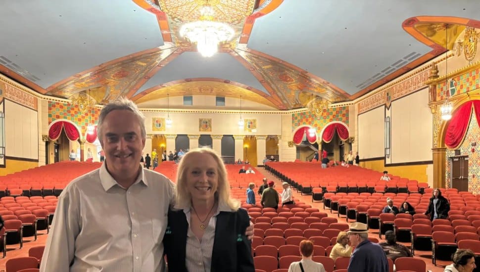 The beautiful restoration of the 1927 Lansdowne Theater can be seen in the background. Matt Schultz of the Historic Lansdowne Theater Corp. stands on stage with U.S. Rep. Mary Gay Scanlon.