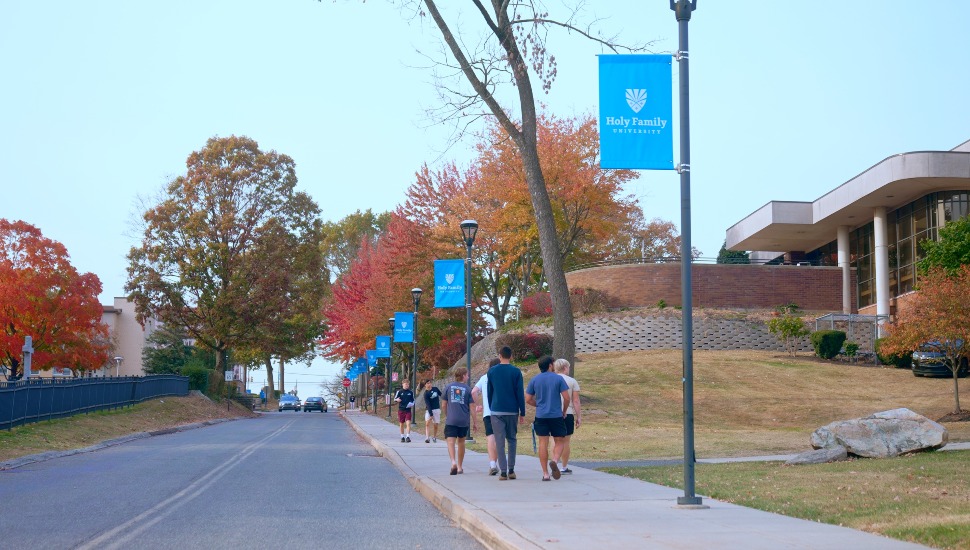 College students walk on sidewalk on campus.