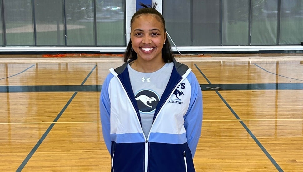 Young female basketball coach in blue and white jacket.