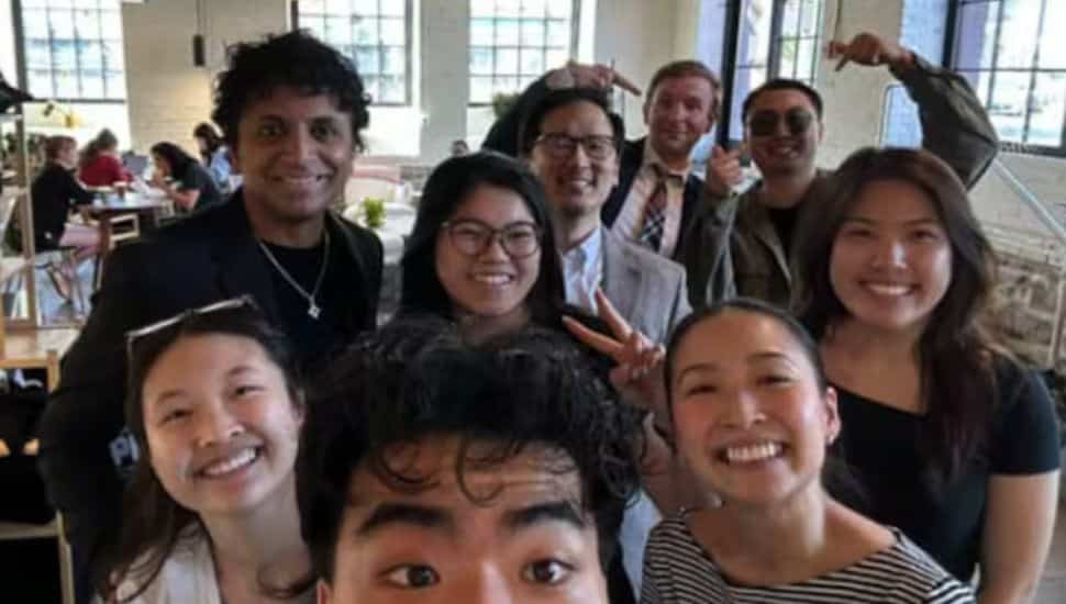 M. Night Shyamalan poses with Càphê Roasters staff.