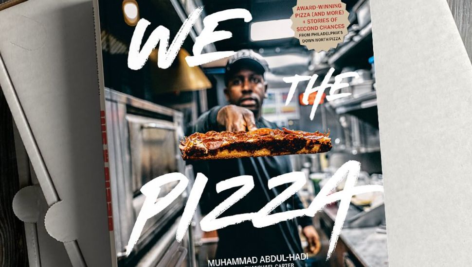 'We the Pizza' Book resting atop pizza boxes.
