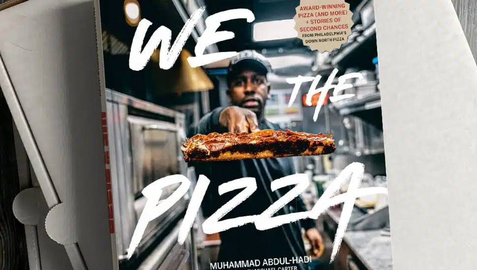 'We the Pizza' Book resting atop pizza boxes.