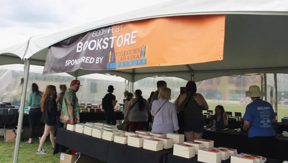 Book enthusiasts gather under a tent filled with books athte seventh annual Bucks County Book Festival.