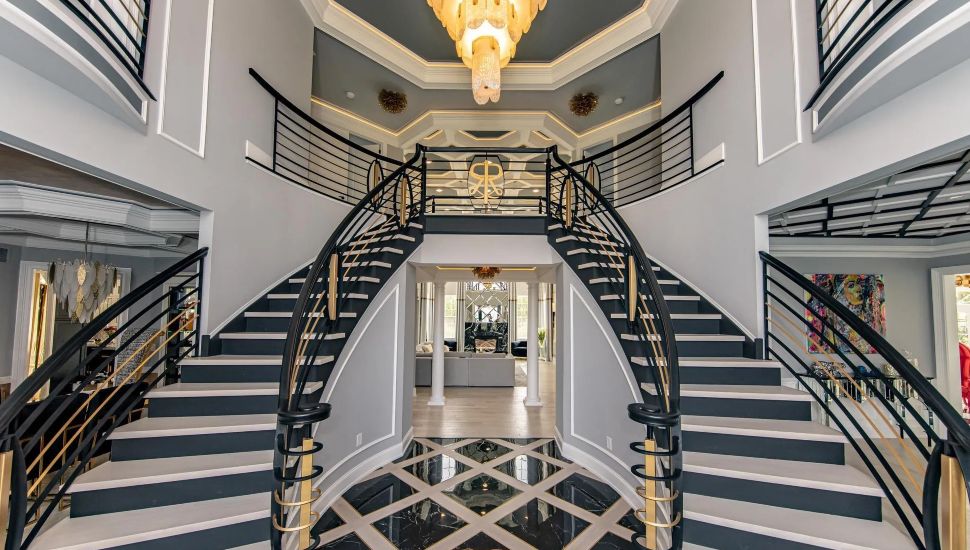 Interior of Ivyland House featuring a grand staircase and chandelier.