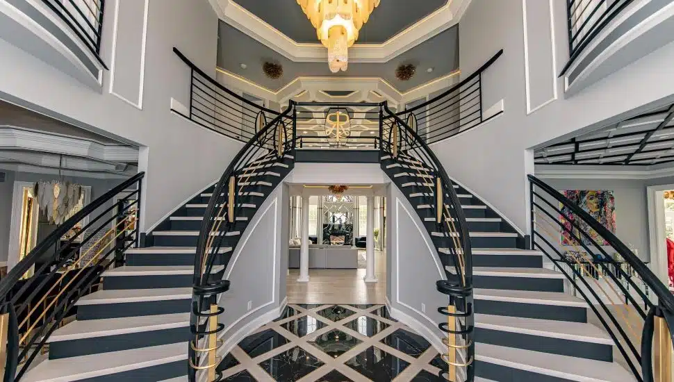 Interior of Ivyland House featuring a grand staircase and chandelier.