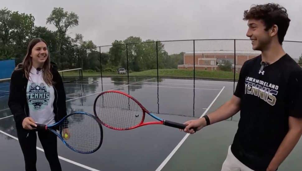 Ava and Gabriel Shapiro with tennis rackets on a tennis court.
