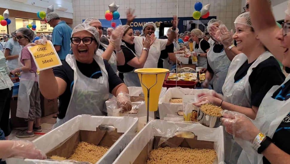 Workers at the BKO Hunger event holding up sign that says "one millionth meal."