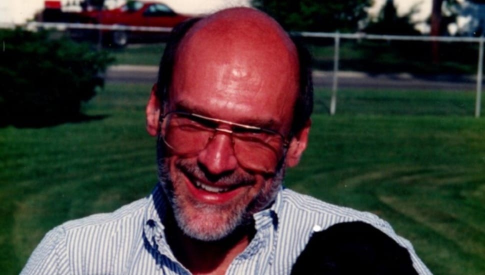 Headshot of middle-aged bald man with gray beard and glasses.