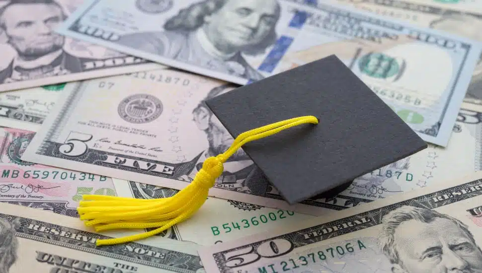Graduation cap university or college degree on US dollars banknotes background.