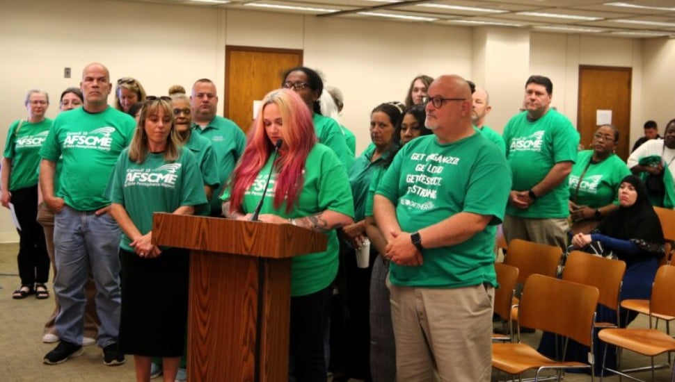 Delaware County Health Department worker Erin Anthony-Russo speaking in front of podium with union members.
