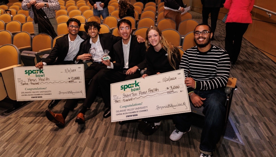 Students receive big checks for winning entrepreneur competition.