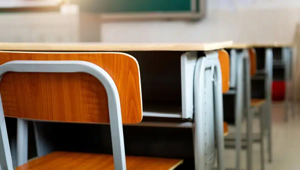 Desk chair and desk in a classroom.
