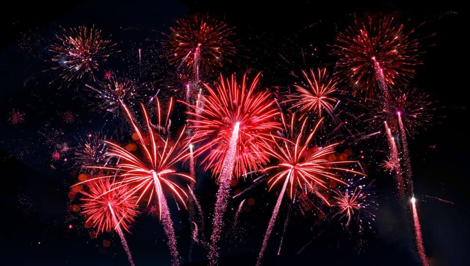 Red fireworks on dark night sky.