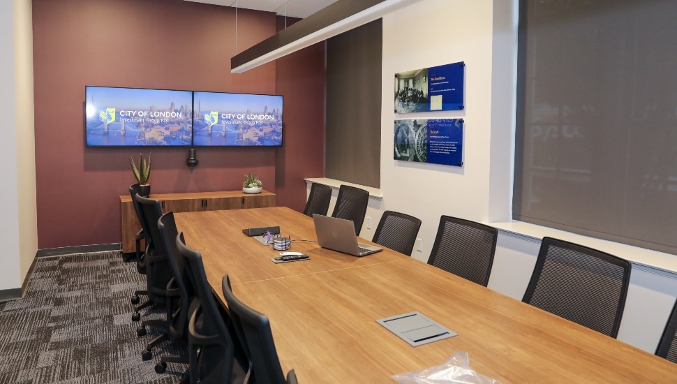 Empty conference room with table, chairs, and monitors.