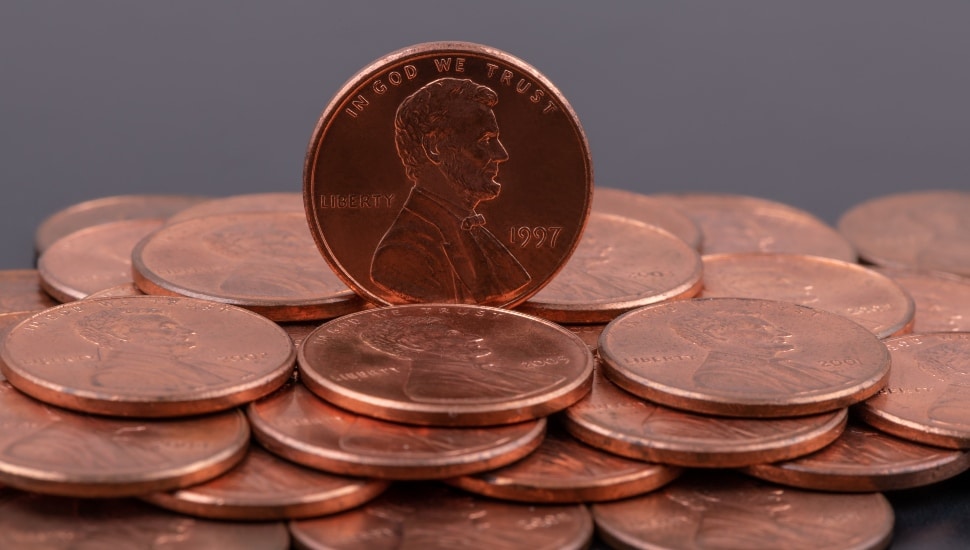 Coins in denominations of 1 American cent with a portrait of Abraham Lincoln on a gray background.